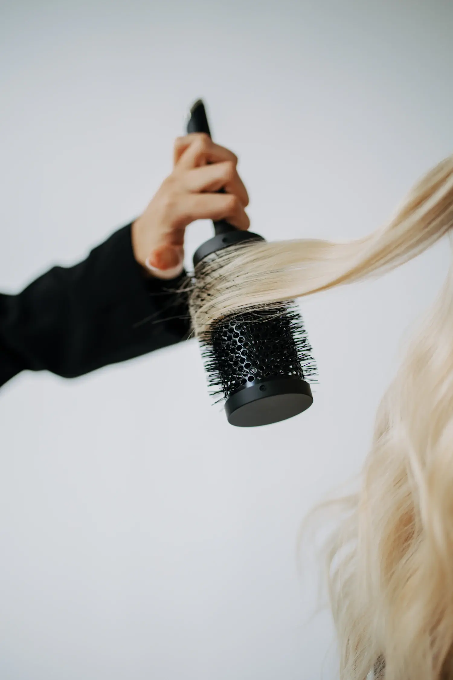 A round brush finishing bright blonde hair